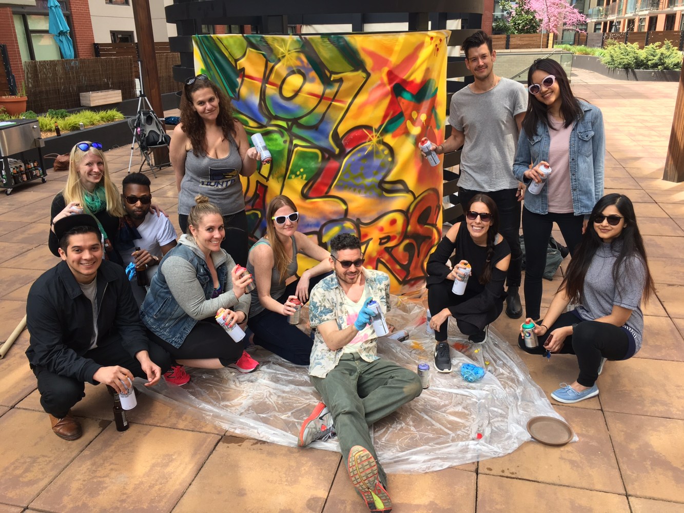 group posing in front of graffiti