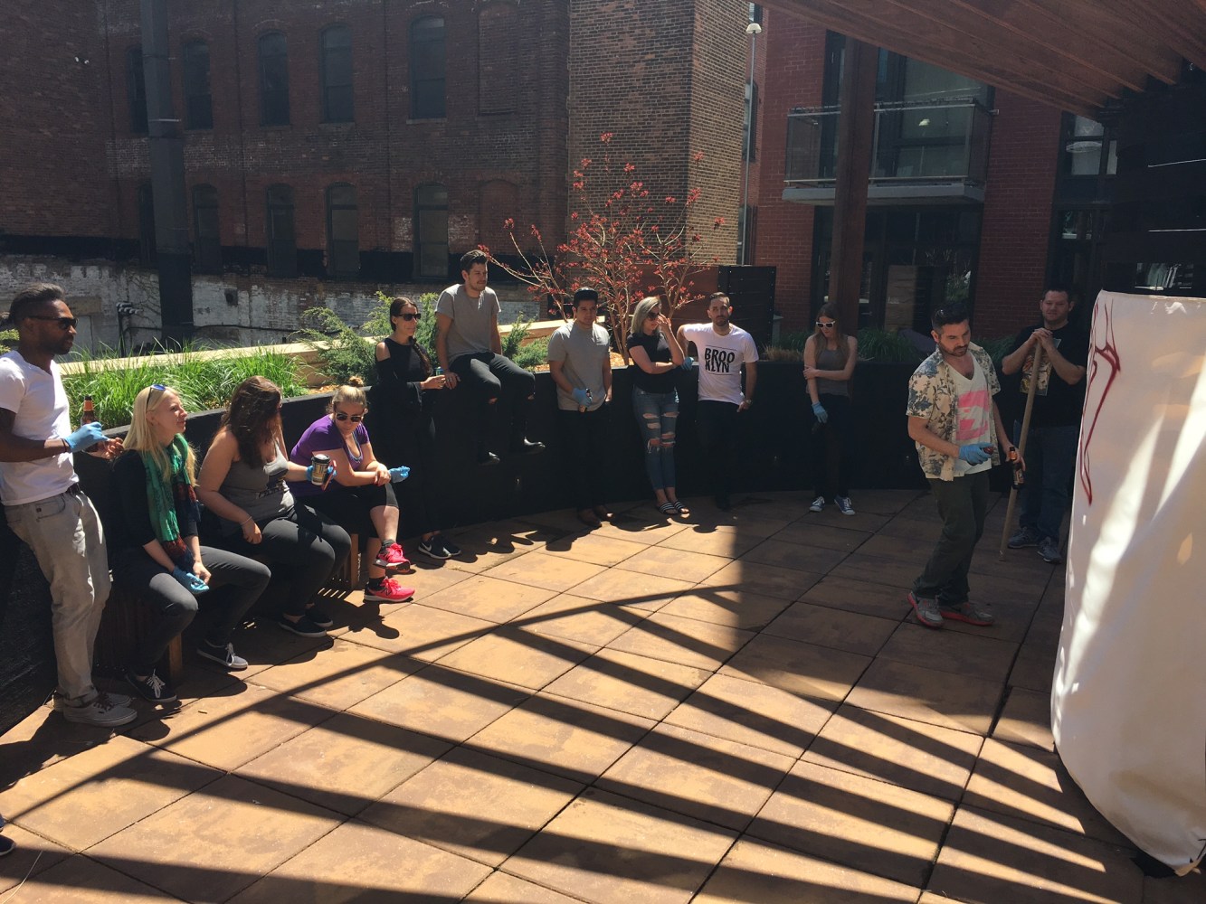 group watching graffiti artist paint