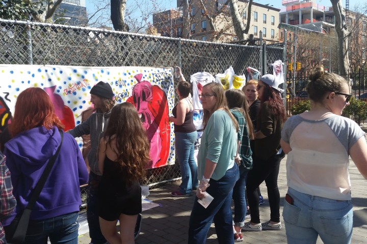 Ramiro teaches kids how to paint using a large Canvas