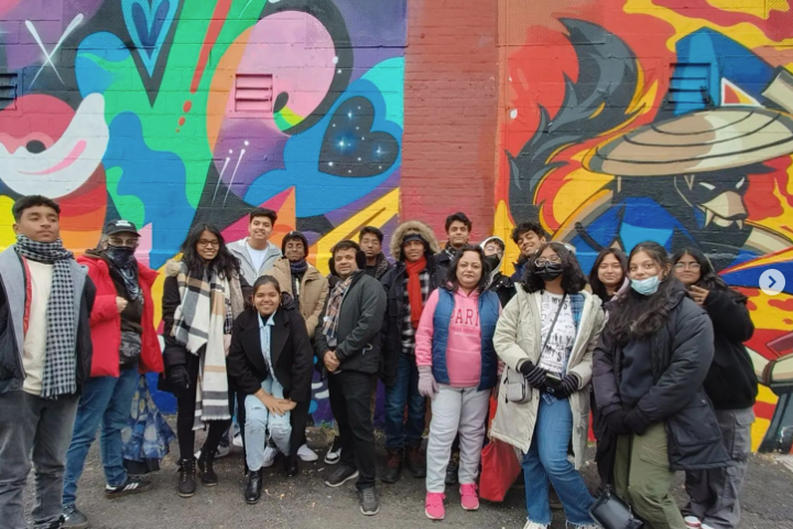 a group of people standing in front of a graffiti wall