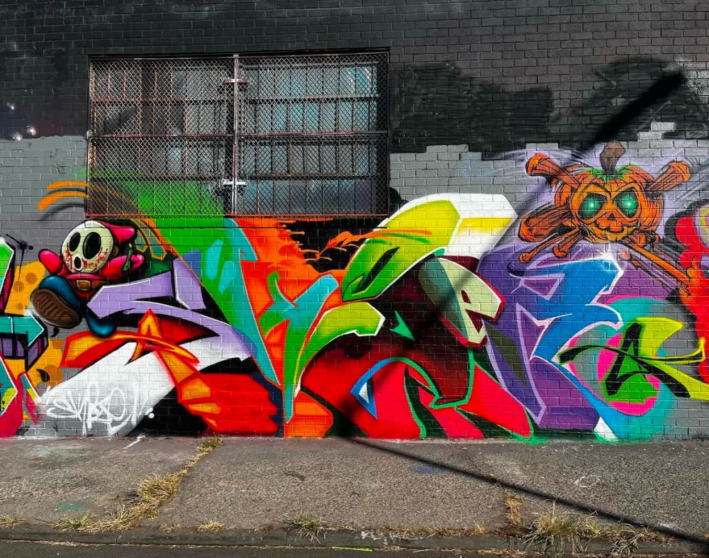 a colorful kite sitting on top of graffiti